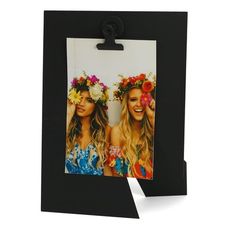 two girls with flower crowns on their heads are standing in front of a black frame