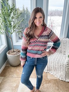 a woman standing in front of a window with her hands on her hips and smiling