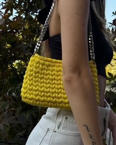 a woman carrying a yellow knitted purse