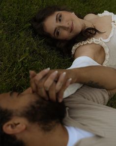 a woman laying on the ground next to a man