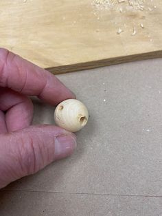 a hand holding a small piece of wood