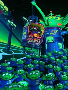 an animated movie scene with many green alien heads and arms, all surrounded by small blue creatures