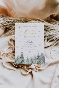 the wedding card is laying on top of a blanket with fur and snowflakes