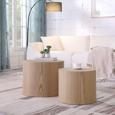 two wooden tables sitting on top of a carpeted floor next to a white couch