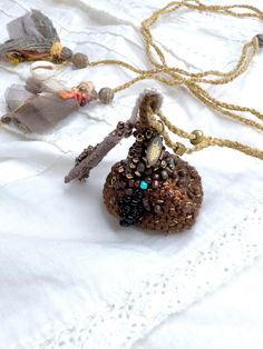 a small beaded bag sitting on top of a white cloth covered table next to a chain