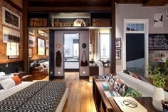 a living room filled with furniture and pictures on the wall next to a doorway that leads into a bedroom