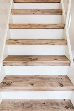 wooden stairs with white painted walls and wood flooring