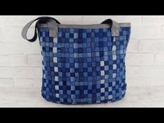 a blue and gray bag sitting on top of a white brick wall