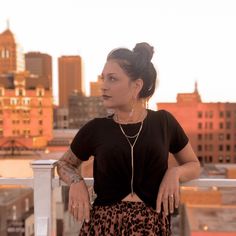 a woman standing on top of a roof next to a tall building with buildings in the background