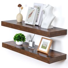 two wooden shelves with pictures and vases on them