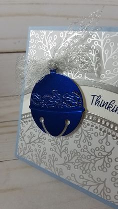 a thank you card with a blue ornament hanging from it's side