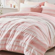 a bed with pink and white striped comforters