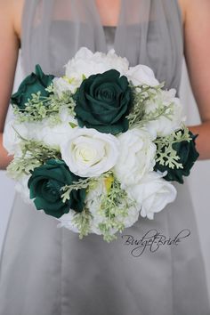 a bride holding a bouquet of white and green flowers