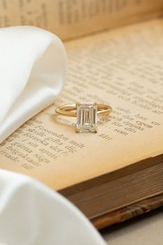 an open book with a ring on top of it