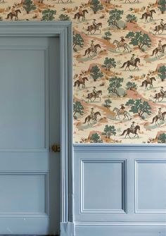 an open door in front of a wallpapered room with horses and trees on it