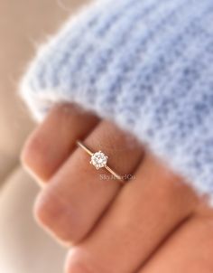 a woman's hand with a diamond ring on her finger, showing the center stone