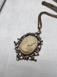 Vintage inspire cameo necklace made with antique gold brass findings and a shimmering resin cameo. Chain length - 52 cm. Cameo height - 5.5 cm, width - 4 cm  victorian cameo pendant, victorian lady cameo necklace, Long Necklace, vintage wedding necklace, statement necklace, bridal necklace, victorian bride, Charm Necklace, Luxury Bling, ,Vintage Inspired, ivory pearl Necklace, Rhinestone Charm, Elegant Necklace, Romantic Necklace, Affordable Gifts, Affordable Present, Bohemian Jewelry, victorian Luxury Cameo Necklaces For Anniversary, Luxury Cameo Necklace For Formal Occasions, Luxury Elegant Cameo Necklace, Elegant Luxury Cameo Necklace, Handmade Presents, Jewelry Affordable, Victorian Bride, Ivory Pearl Necklace, Victorian Cameo