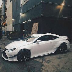 a white sports car parked in front of a building