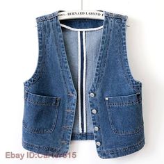 a denim vest hanging on a white wall