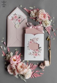 wedding stationery with pink flowers and greenery on grey background, including envelopes