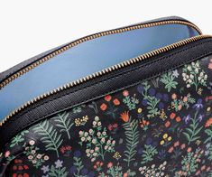 a black floral print purse with gold zippers