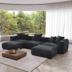 a living room with a large sectional couch and coffee table in front of the window