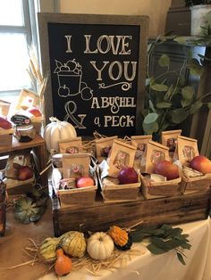 an assortment of fruits and vegetables displayed on a table with a sign in the background