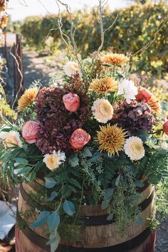 a wooden barrel filled with lots of flowers