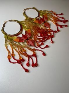 Beautiful Red, orange, and yellow seed bead Phoenix hoop earrings. Party Beaded Hoop Earrings With Round Beads, Party Hoop Earrings With Round Beaded Details, Handmade Hoop Beaded Earrings For Party, Red Bohemian Hoop Earrings For Summer, Yellow Colorful Beaded Hoop Earrings, Festive Multicolor Beaded Hoop Earrings, Yellow Beaded Hoop Earrings, Orange Small Hoop Earrings For Summer, Yellow Beaded Round Hoop Earrings