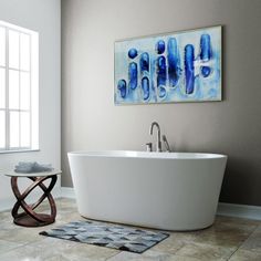 a white bath tub sitting under a window next to a rug on top of a tiled floor