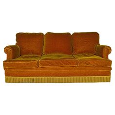 an orange couch sitting on top of a white floor