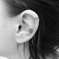 a woman's ear with black cat ears and nose piercings on her left side