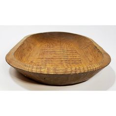 a wooden bowl sitting on top of a white table