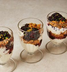 three desserts in small glass dishes on a table