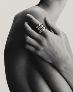 black and white photograph of woman's arm with ring on top of her shoulder