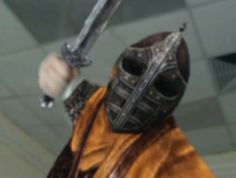 a close up of a person wearing a mask and holding a knife in one hand