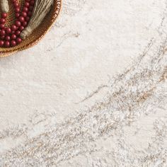 a basket filled with red berries on top of a white rug