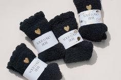 four pairs of black socks with gold hearts on them and labels that say, i love you more