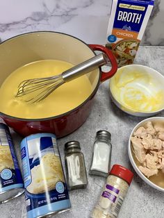 ingredients to make chicken soup laid out on a marble counter top, including milk, eggs, butter, and seasonings