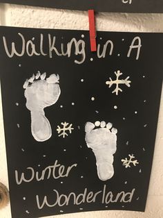 a sign that says walking in a winter wonderland with two feet and snowflakes on it