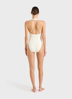 Indulge in timeless sophistication with the Candice One Piece Swimsuit in Porcelain. Effortlessly elegant, this swimsuit transcends trends, promising enduring style. Its versatility extends beyond the beach, doubling as a chic bodysuit under trousers or a skirt. Revel in comfort with its wide, elasticated strap, while the alluring scoop back adds a touch of allure. Elevate your swimwear collection with this epitome of luxury. Summer Halter Neck Bodysuit With Built-in Bra, Chic High Stretch Swimwear With Built-in Bra, Elegant Halter Top With Built-in Bra For Vacation, White Halter Neck Swimwear With Built-in Bra, Chic Fitted Smoothing Swimwear, Chic Smoothing Swimwear For Beach, Elegant White Swimwear With Built-in Bra, Stretch Halter Neck Swimwear In Elastane, Elastane Halter Neck Swimwear