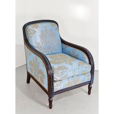 a blue and gold upholstered chair sitting in a room