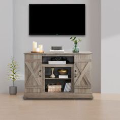 an entertainment center with a flat screen tv mounted on it's wall, next to a potted plant