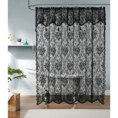 a black and white shower curtain hanging on a wall next to a bathtub in a bathroom