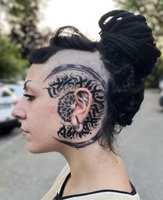 a woman with tattoos on her face and ear