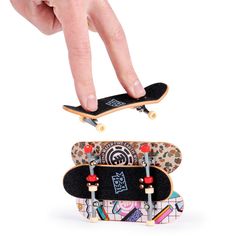 two skateboards are stacked on top of each other and being held by someone's hand