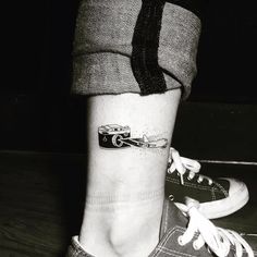 a black and white photo of someone's foot with a tattoo on it