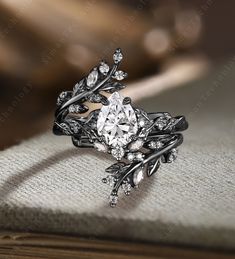 a close up view of a ring with leaves and diamonds on it's sides