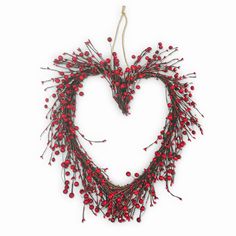 a heart shaped wreath with red berries hanging from it