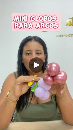 a woman sitting at a table with balloons in front of her and the words mini globos para arcos